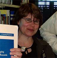 Carol Eden displaying one of the educational courses
